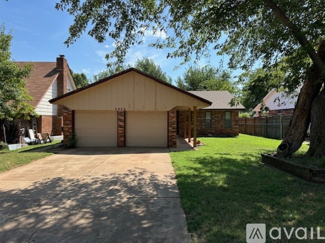 A two-car garage with a brick pillar and a sign that says 5472.