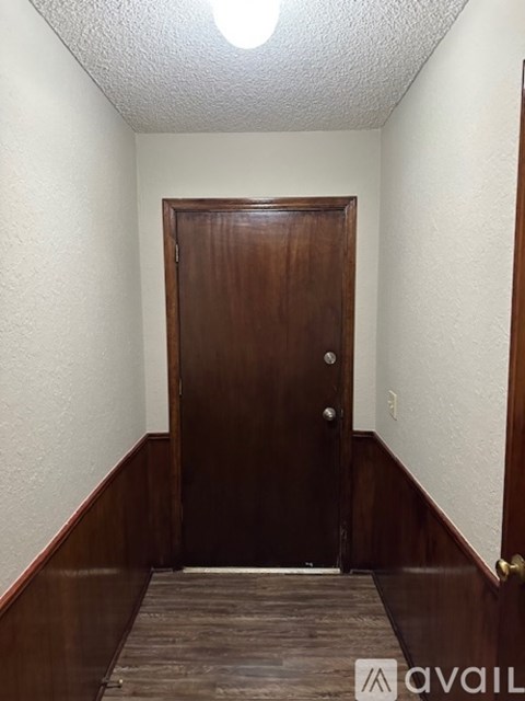 A brown door is in a room with a tiled floor.