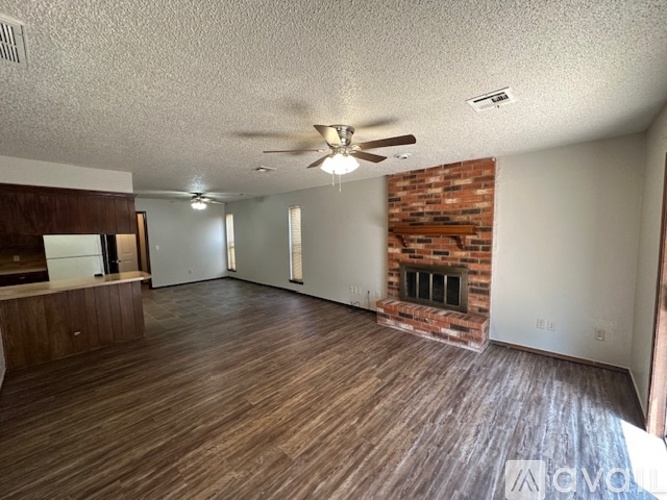A kitchen with a white fridge and brown cabinets.