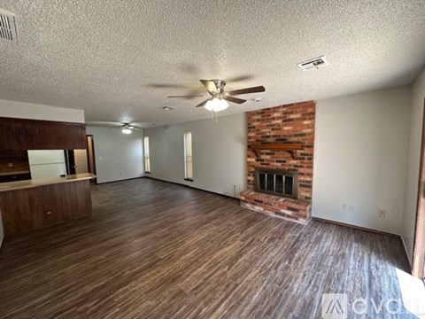 A kitchen with a white fridge and brown cabinets.