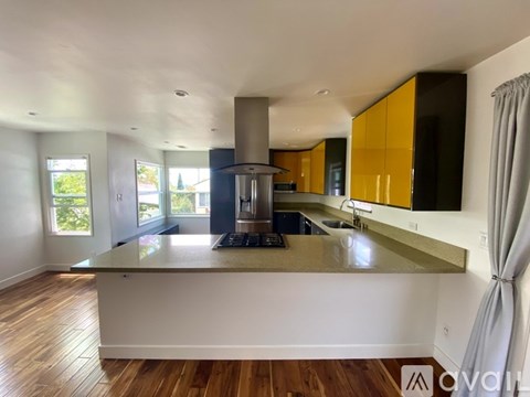 A modern kitchen with a large island and a stove.