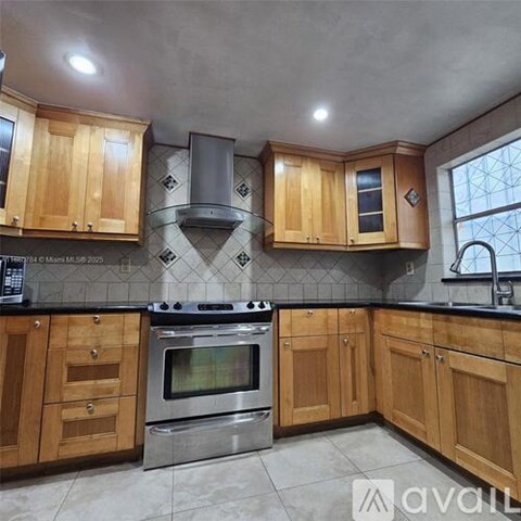 A kitchen with wooden cabinets and a stainless steel oven.