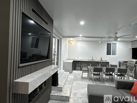 A modern living room with a television and a dining table.