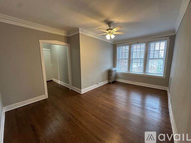 A room with wooden floors and a ceiling fan.