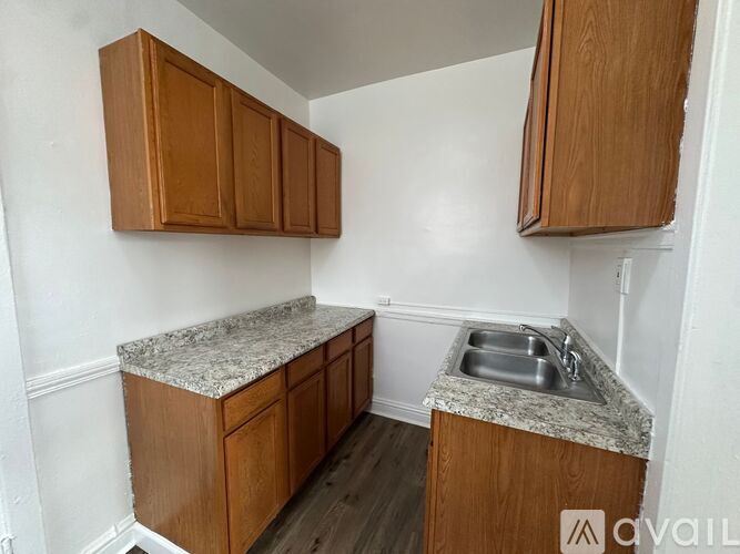 A kitchen with wooden cabinets and a granite countertop.
