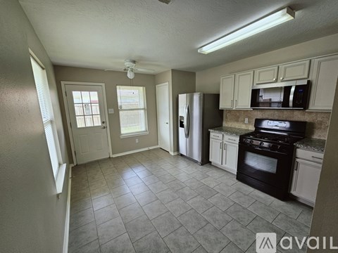 A kitchen with tile flooring and a refrigerator.