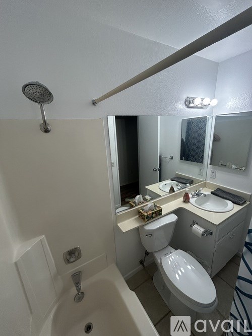 A white bathroom with a toilet, sink, and shower.