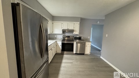 A kitchen with a stainless steel refrigerator and a stove top oven.
