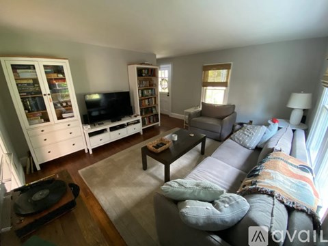A living room with a grey couch and a wooden coffee table.