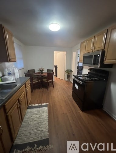 A kitchen with wooden cabinets and a dining table with chairs.