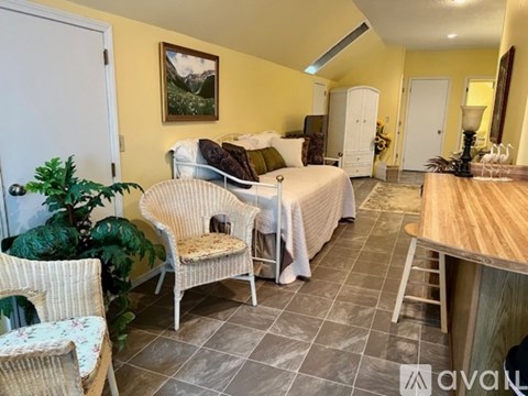 A living room with a sofa, chair, and a painting on the wall.