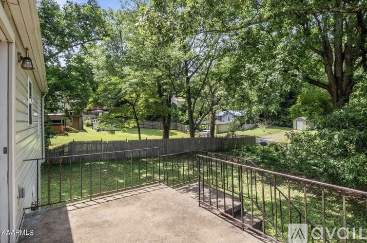 A backyard with a fence and trees.
