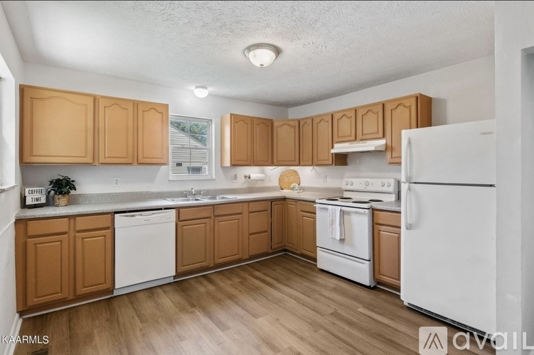 A kitchen with wooden cabinets and white appliances.