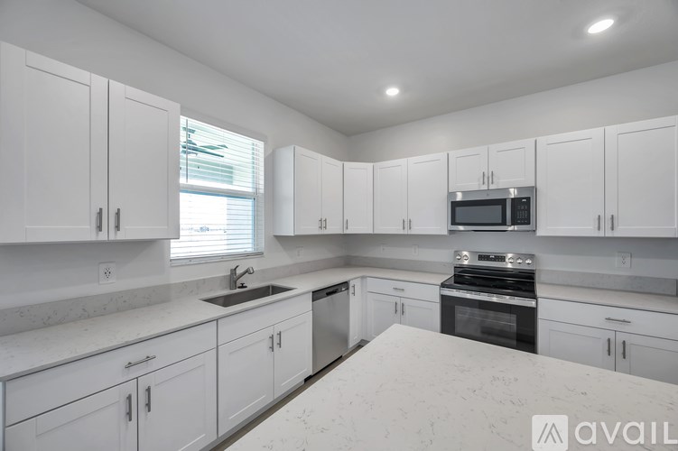 A kitchen with white cabinets and appliances.