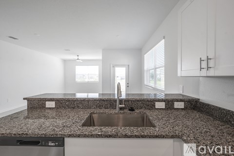 A kitchen with granite countertops and stainless steel appliances is available for rent.