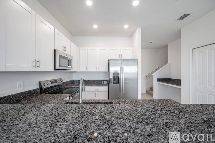 A kitchen with granite countertops and stainless steel appliances.