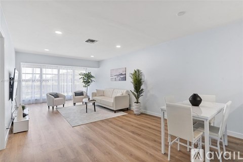 A living room with white furniture and a flat screen TV.
