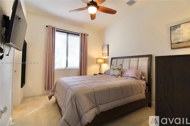 A bedroom with a large bed and a ceiling fan.
