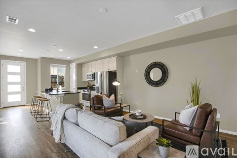 A modern living room with a grey sofa and a brown armchair.