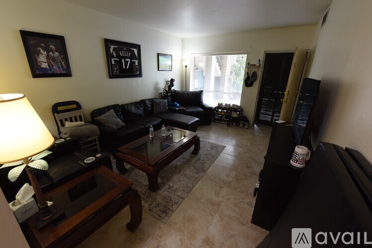 A living room with a black couch and a coffee table.