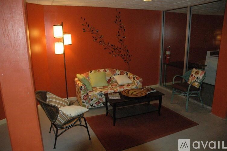 A living room with a sofa, chair, and lamp.