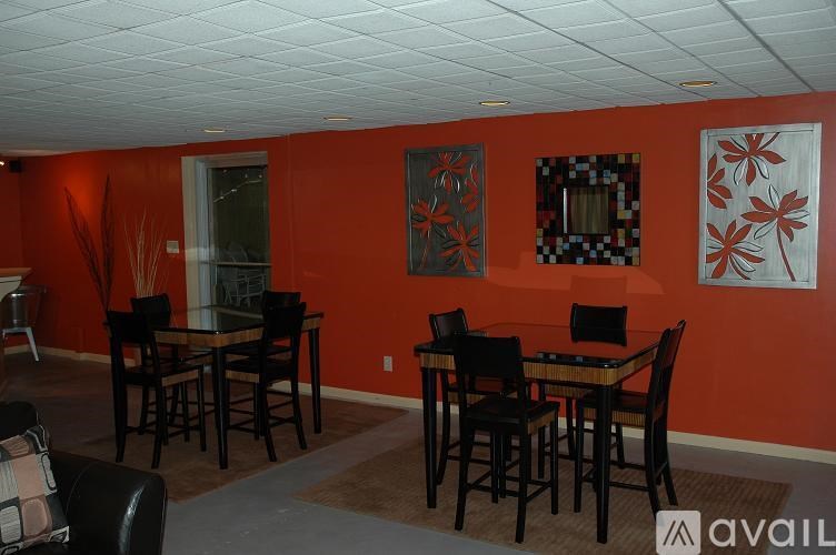 A dining room with a table surrounded by chairs.