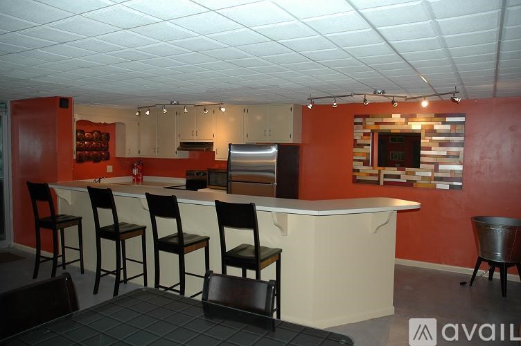 A kitchen with a bar area and chairs.