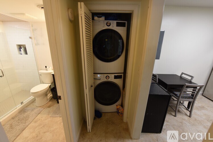 A small room with a washing machine in the doorway.