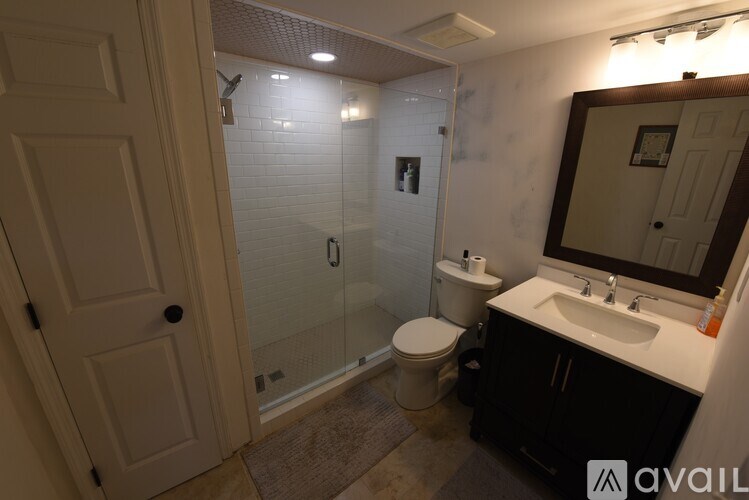 A bathroom with a toilet, sink, and shower.