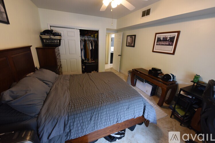 A bedroom with a bed, a desk, and a closet.