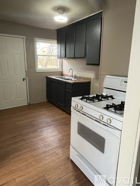 A kitchen with a white stove and black cabinets.