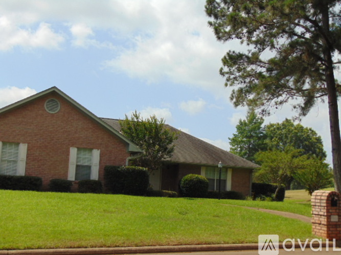 A house with a brick exterior and a green lawn.
