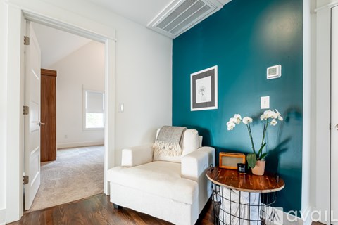 A living room with a white couch and a small table with flowers on it.