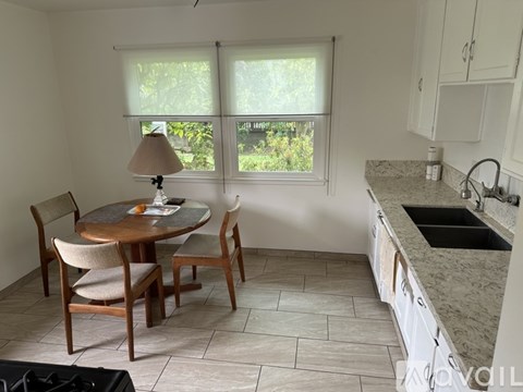 A kitchen with a table and chairs by a window.