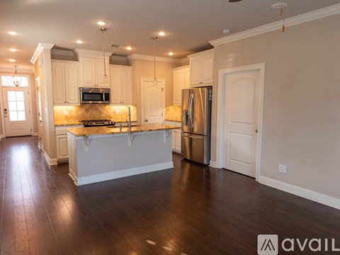A kitchen with white cabinets and a wooden island.