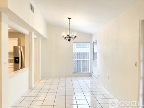 A long hallway with a chandelier hanging from the ceiling.