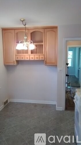 A kitchen with a cabinet and a chandelier.