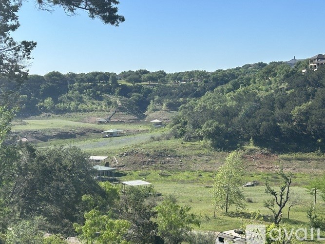 A rural landscape with trees and a clear sky.