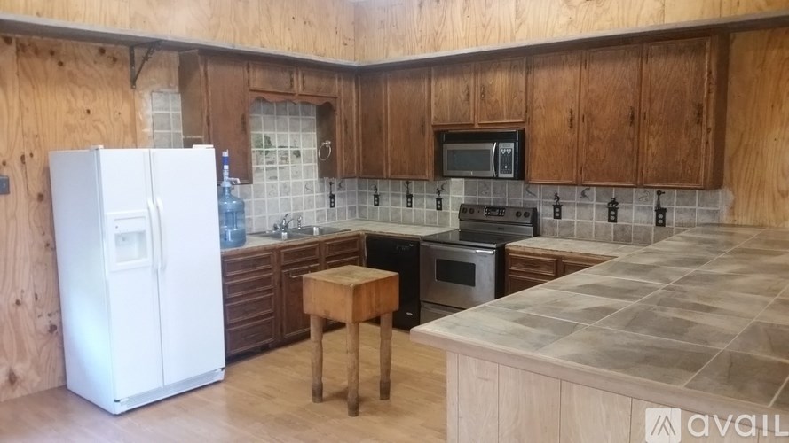 A kitchen with wooden cabinets and a white fridge.