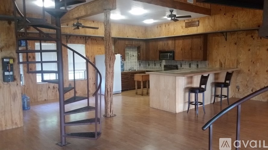 A wooden barn-like room with a spiral staircase.