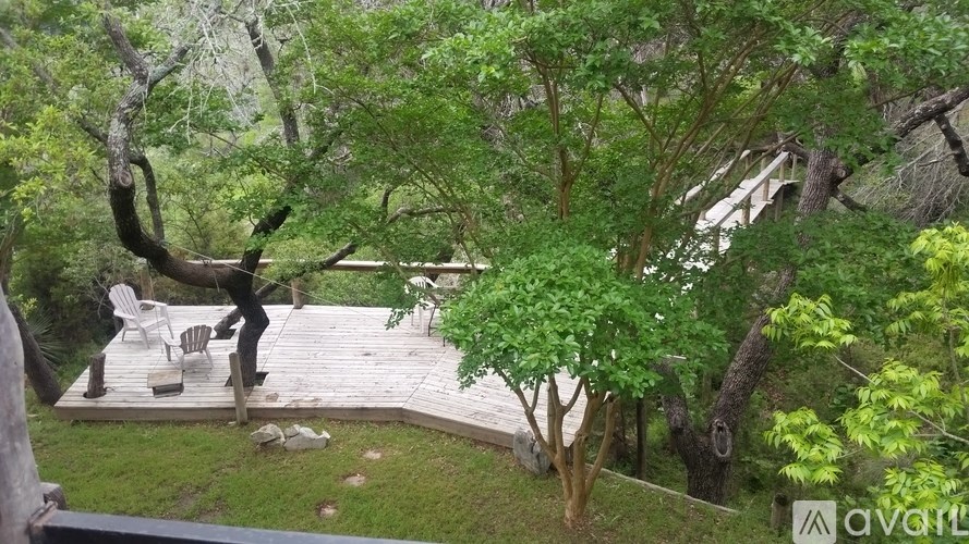 A wooden deck surrounded by trees and bushes.