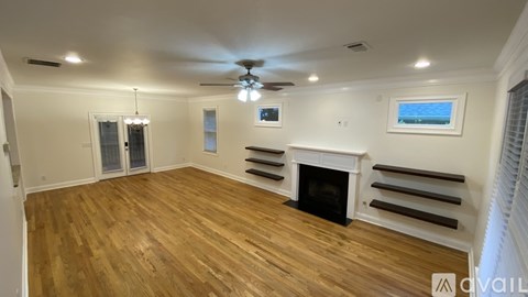 A spacious living room with a fireplace and a painting on the wall.