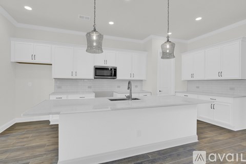 A modern kitchen with white cabinets and a center island.