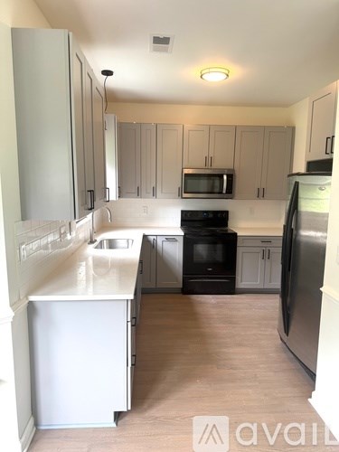 A kitchen with white appliances and cabinets.