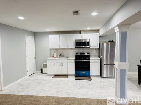 A kitchen with white cabinets and a black stove top oven.