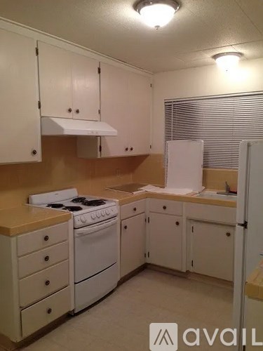 A kitchen with white appliances and cabinets.