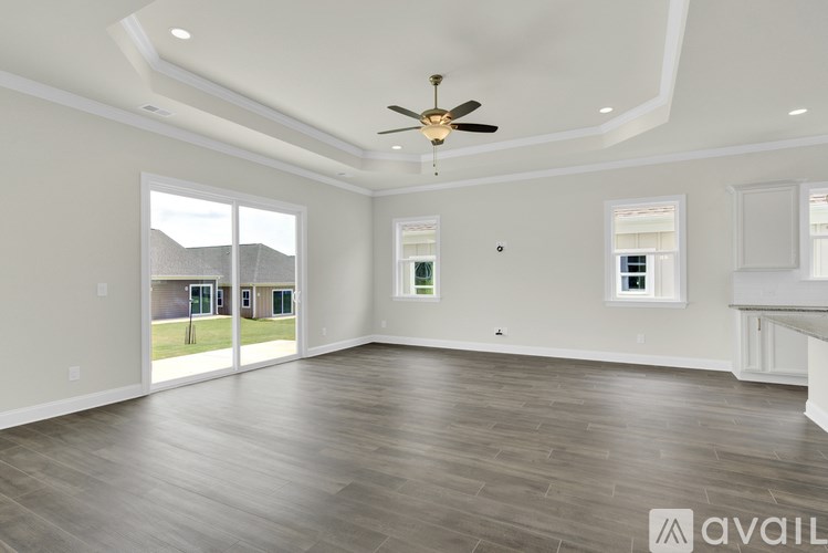 A spacious room with a ceiling fan and large windows.
