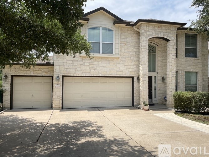 A house with a stone facade and two garage doors.