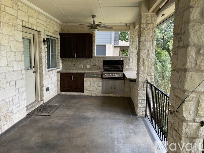 A patio with a grill and a fan.