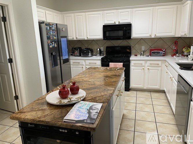 A kitchen with a granite countertop and white cabinets.